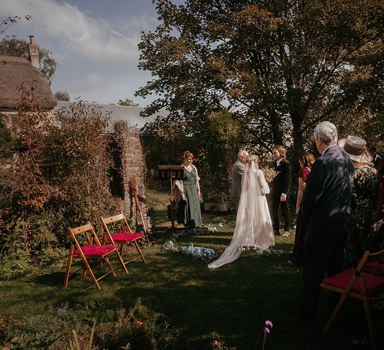 Bride & groom marry during Pagan wedding outdoors with boho and festival styling