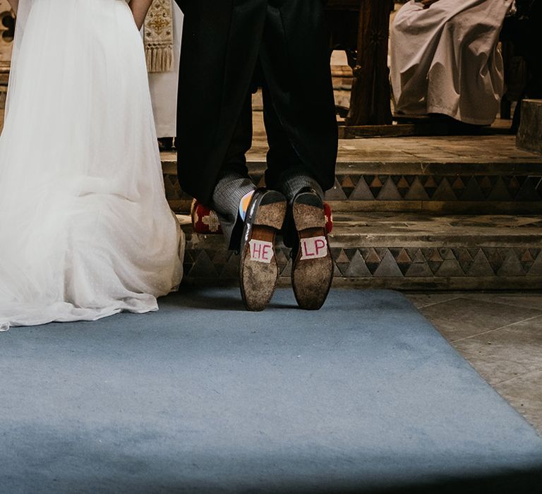 Bride and groom at the alter of Kelmarsh Hall, "help" written on the groom's shoes