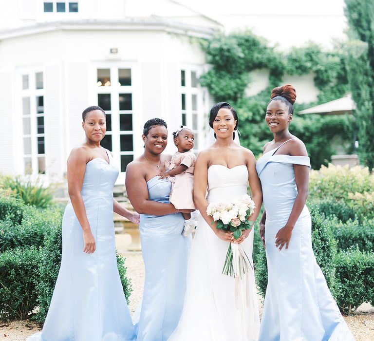 Black bride with bridesmaids in pale blue dresses in mismatched styles 