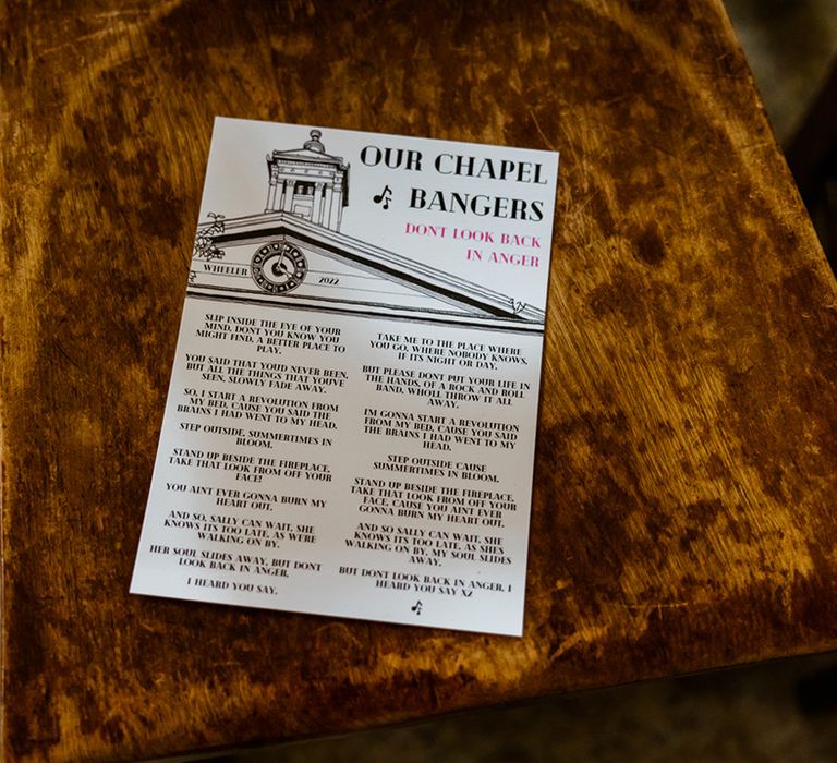 Wedding stationery on wooden chair featuring Don't Look Back In Anger by Oasis 