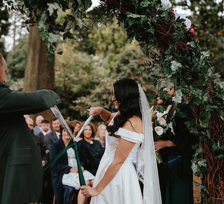 Bride & groom during handfasting ceremony outdoors at the Royal Botanic Garden Edinburgh