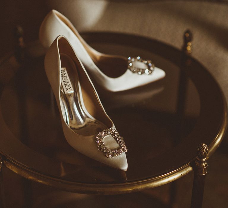 White stiletto pumps with bejewelled pendant by Badgley Mischka