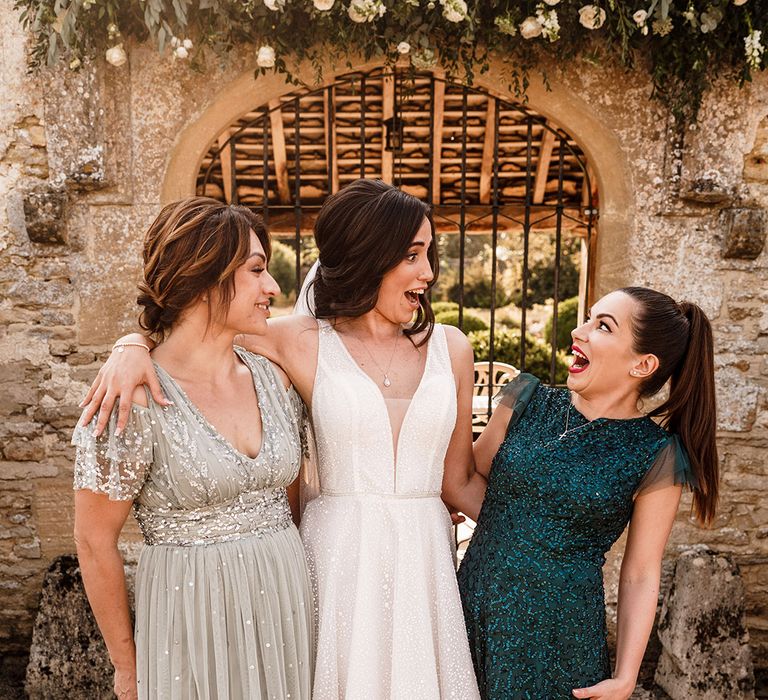 bride in a white sparkly wedding dress and light and dark green sparkly mismatched bridesmaid dresses 