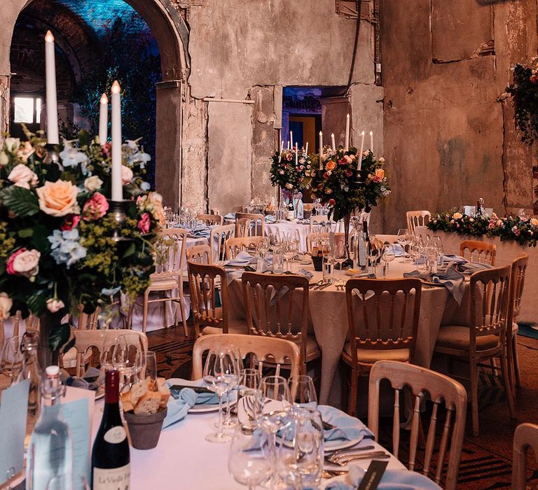 Mansion wedding at The Grange in Hampshire with a light baby blue wedding tablescape with tall centrepieces and fake candles 