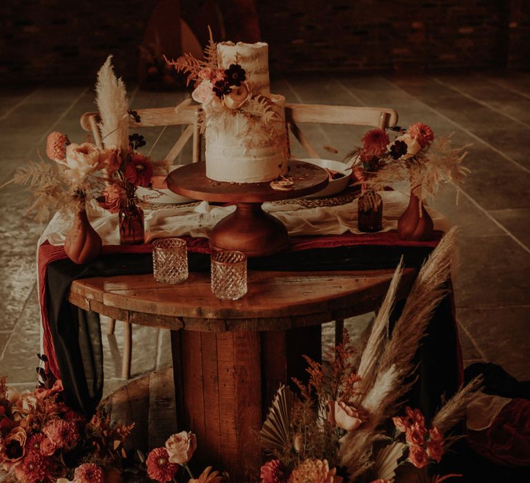 Semi-naked rustic wedding cake decorated with dried wedding flowers for a fall wedding 