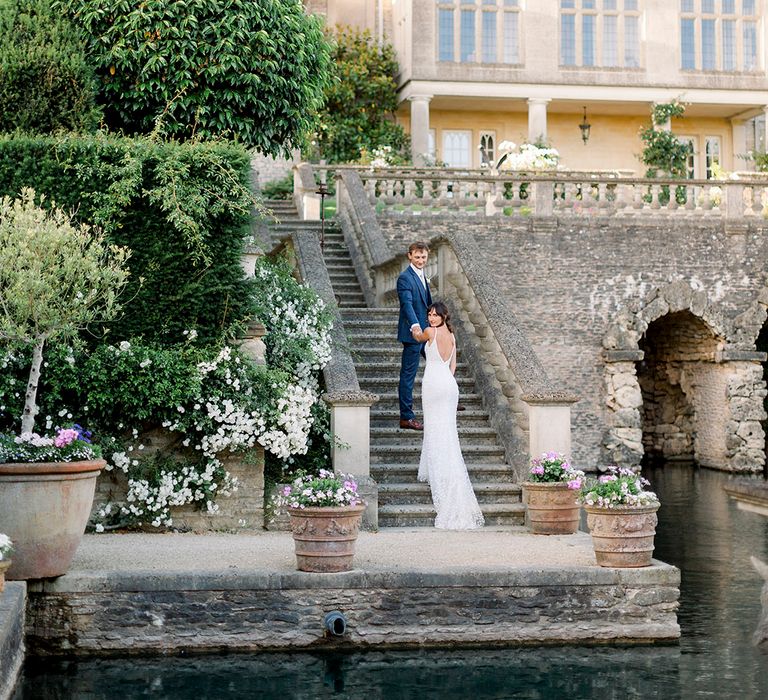 Italian themed wedding at Wiltshire wedding venue with bride and groom climbing the steps 