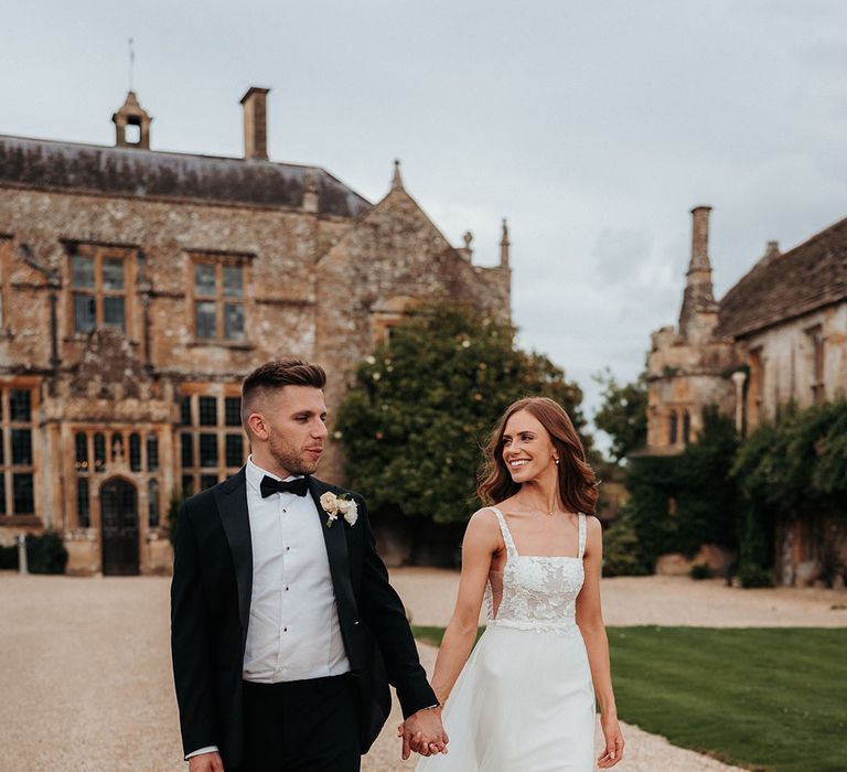 Bride in Made With Love wedding dress with groom in black tuxedo for timeless wedding with tradtional wedding fashion 