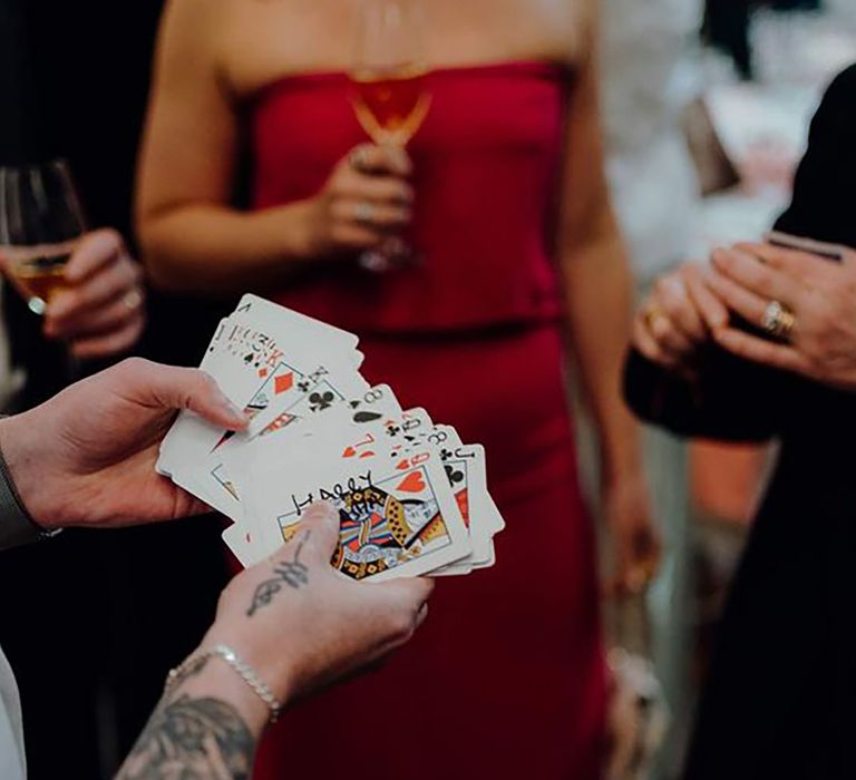 Magician holding deck of cards at wedding presenting a trick to guests