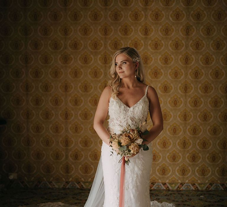 Bride in classic lace wedding dress with colourful round wedding bouquet 