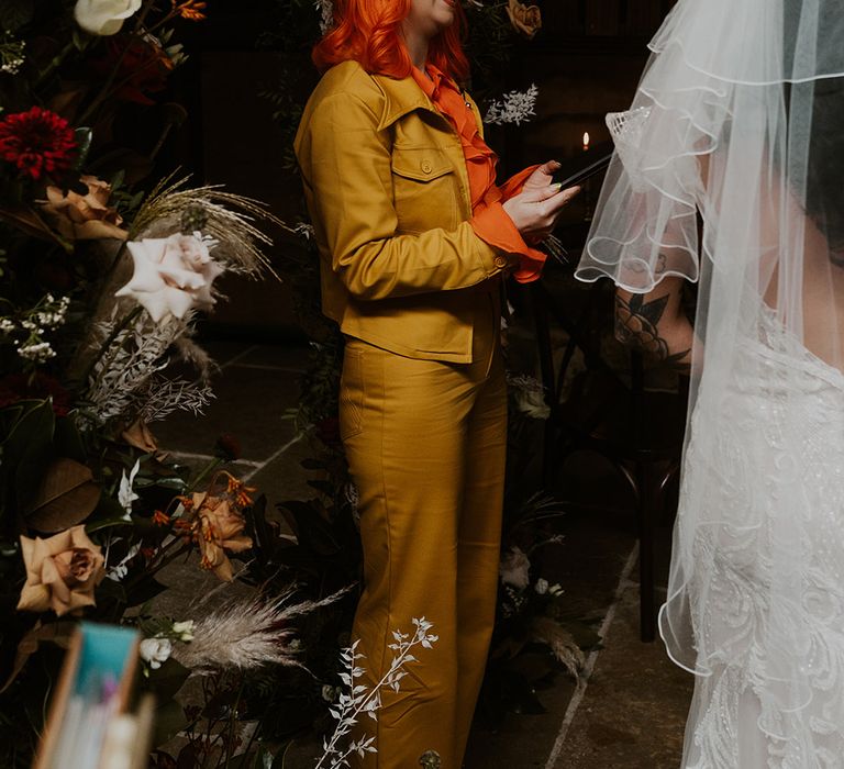 Wedding celebrant in yellow coord set with bright orange hair at Willow Marsh Farm 