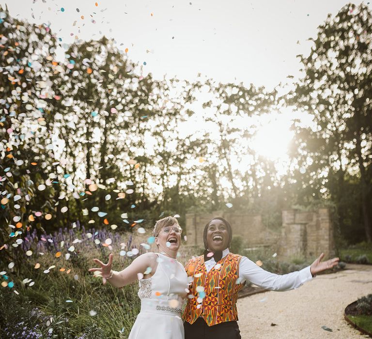 Brides at golden hour as the pastel confetti falls around them at Bowcliffe Hall wedding 