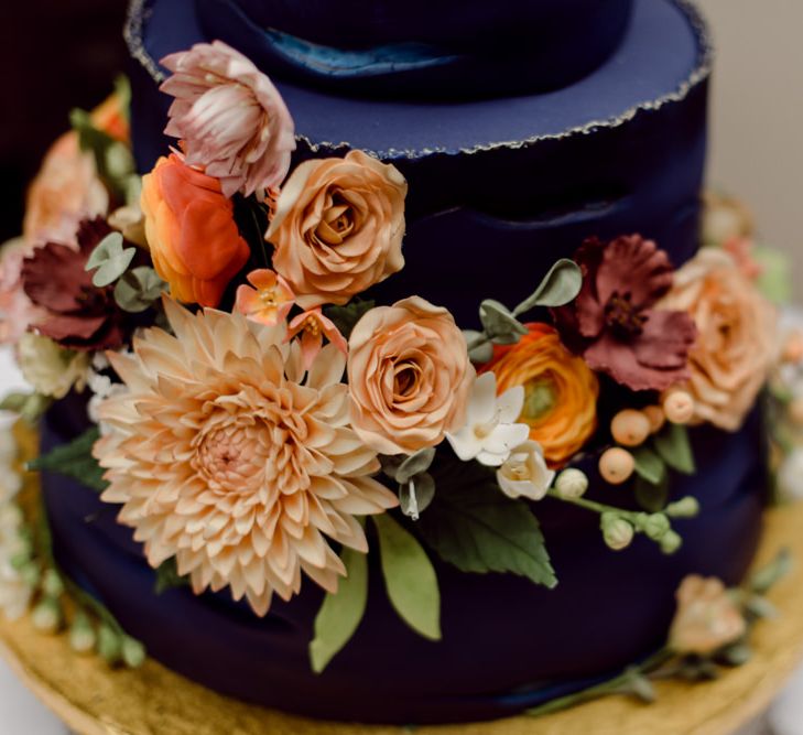 Navy blue wedding cake with floral decor