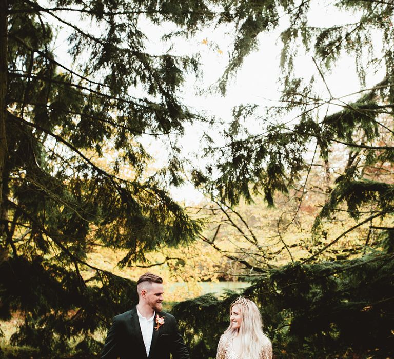 Bride and groom walking through woodland. Photography by Maryanne Weddings.