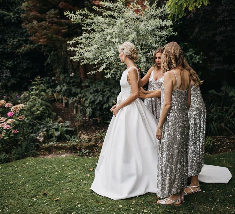 Bridesmaids in silver sequin midi dresses and sandals 