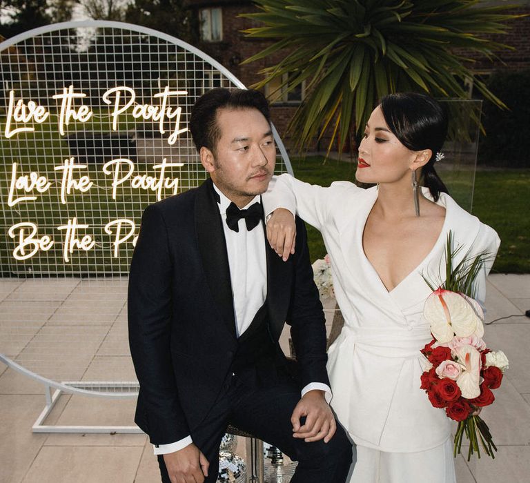 Stylish bride and groom in black tuxedo and a white bridal suit