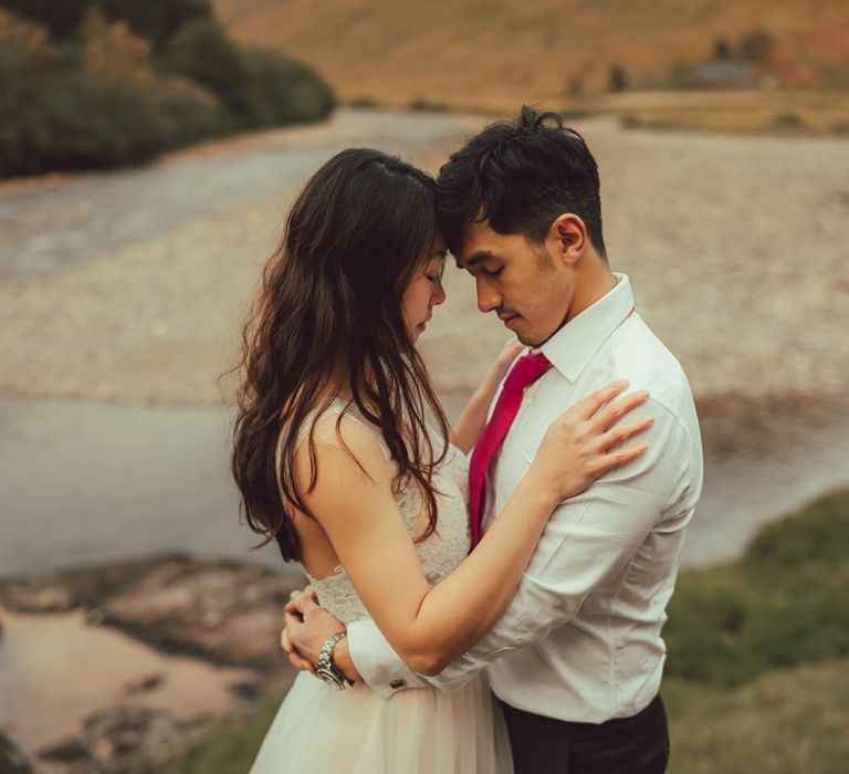 Couple embrace lovingly in the Scottish countryside