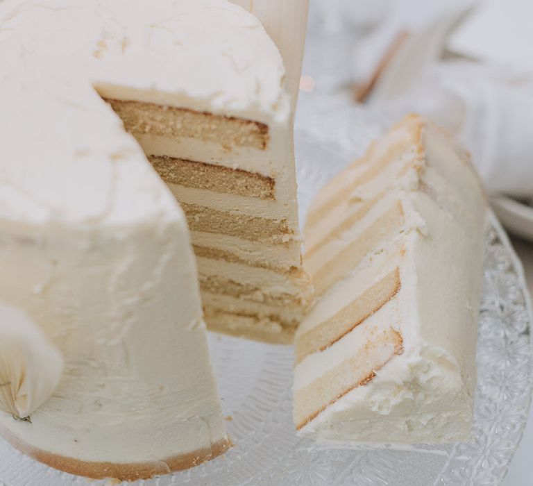 Simple, one tier naked wedding cake with buttercream layers for all white wedding inspiration