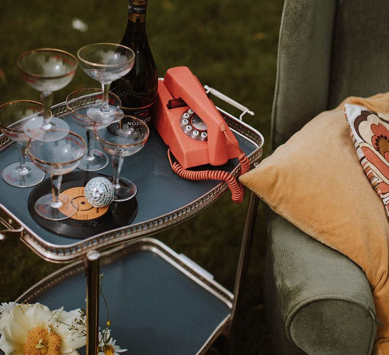 Drinks trolly with coupe champagne glasses and retro telephone