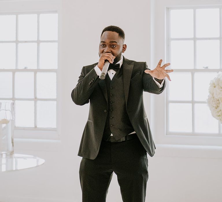 Groom during wedding speech wearing black tie and patterned waistcoat 