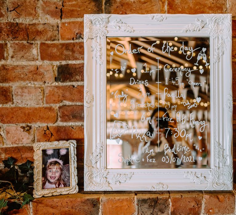 Order Of The Day written on mirror with pictures of brides as children next to it