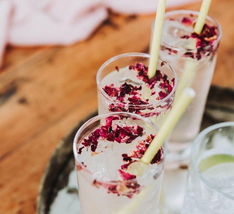 Gin cocktails complete with dried edible florals in pink and paper straws 