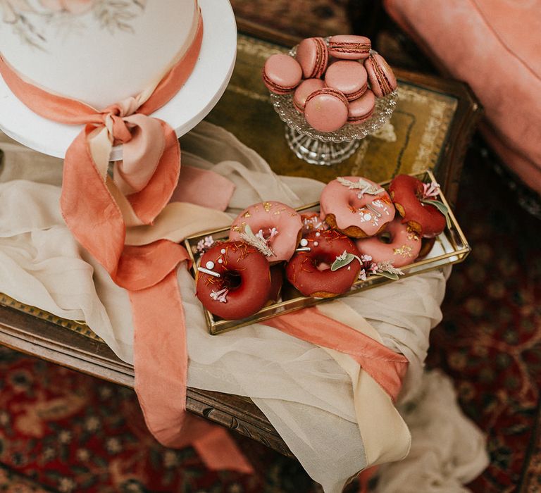 Pink and brown glazed doughnuts on coffee table dessert station 