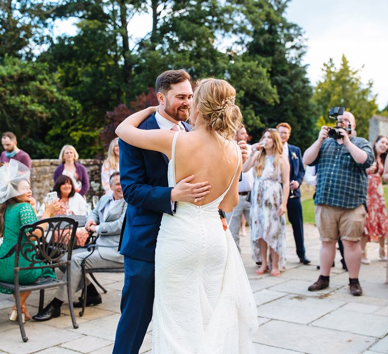 Surprise first dance with bride in an fitted, beaded Made With Love wedding dress with straps, low back and button detail 