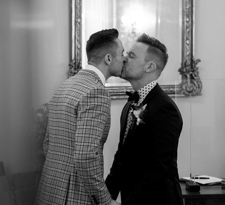 Grooms kiss on their wedding day in black & white image