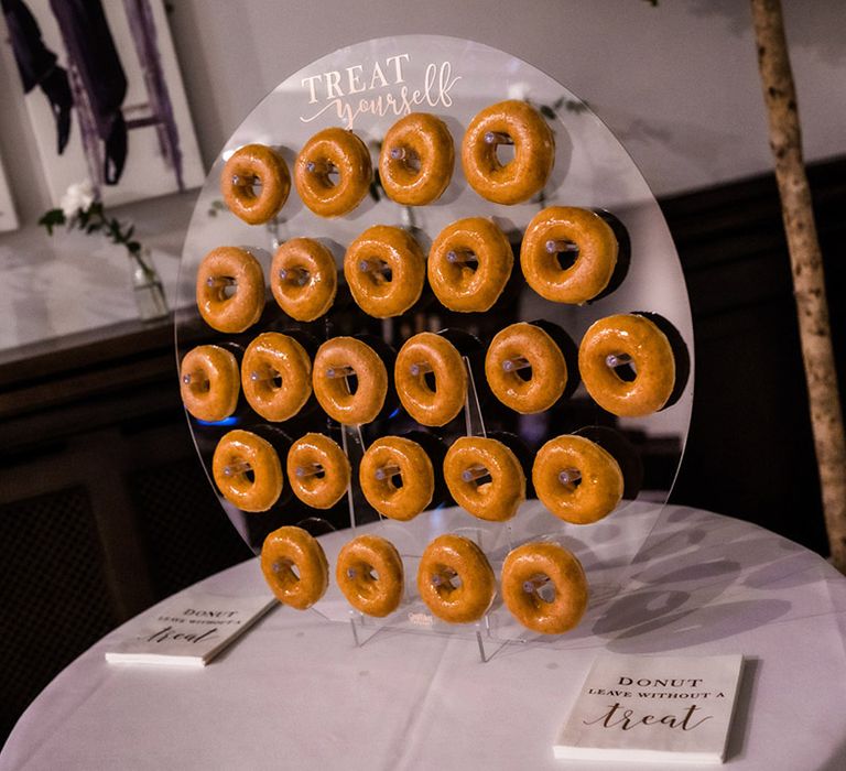 Circular doughnut wall reading 'treat yourself' with glazed doughnuts and napkins with pun 