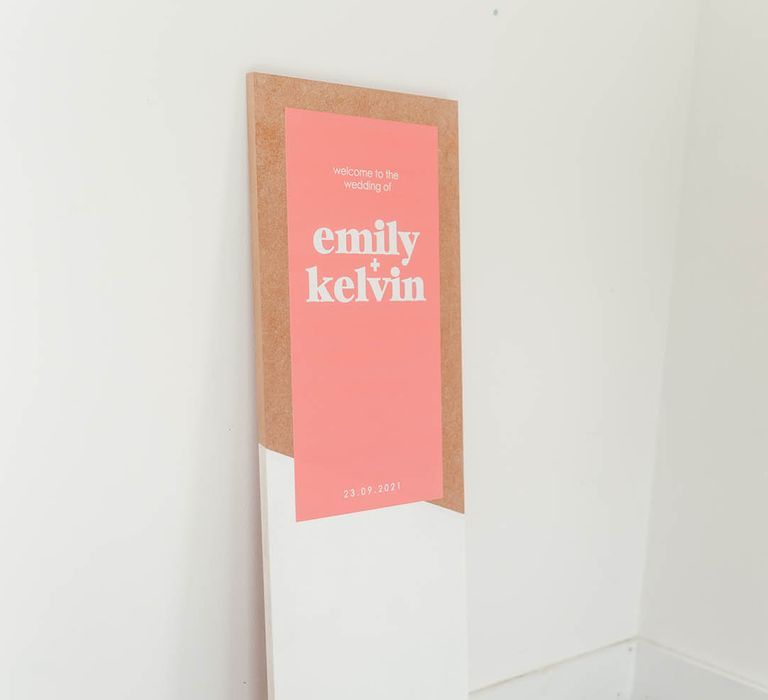 Pink wedding welcome sign with white font on tall rectangular board for industrial style wedding 