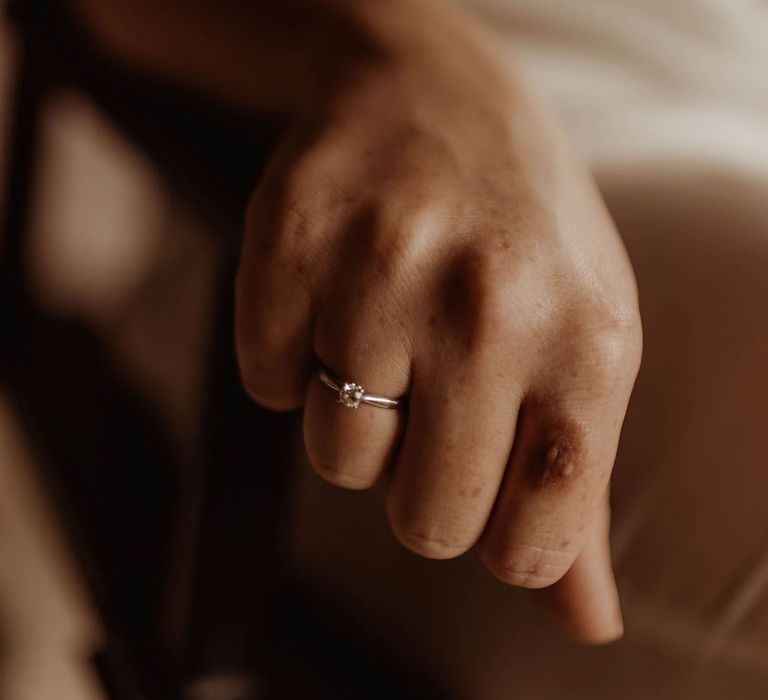 Thin silver band with circular diamond engagement ring