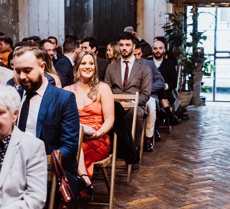 Wedding guests sit waiting for the ceremony to begin 