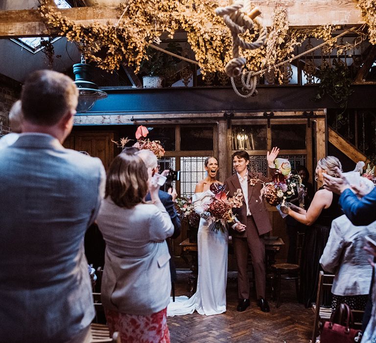 Bride and groom face their wedding guests as husband and wife 