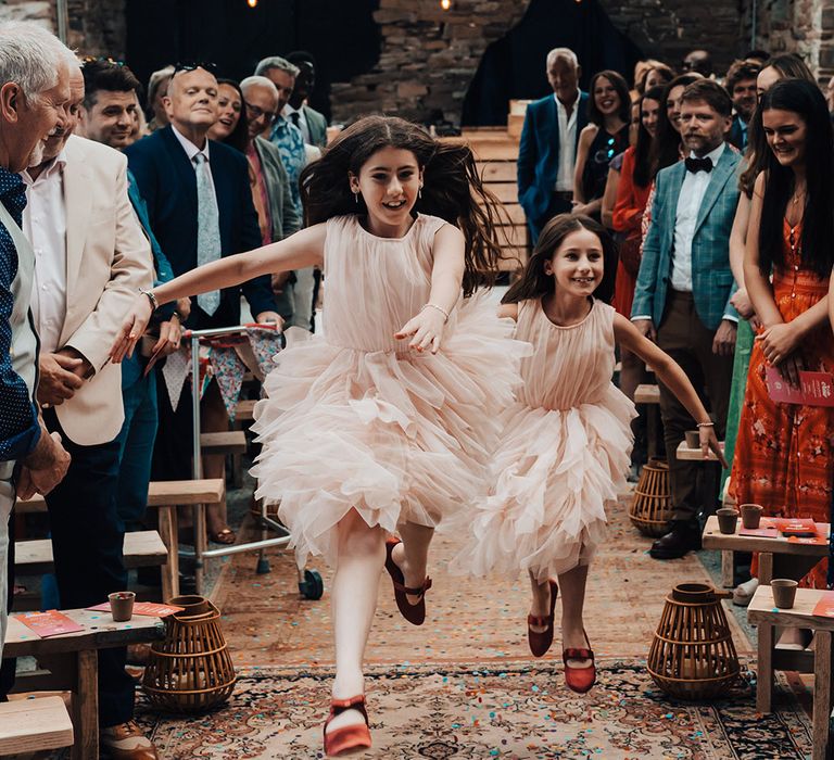 Flower girls in pink tulle dresses in bow shoes 