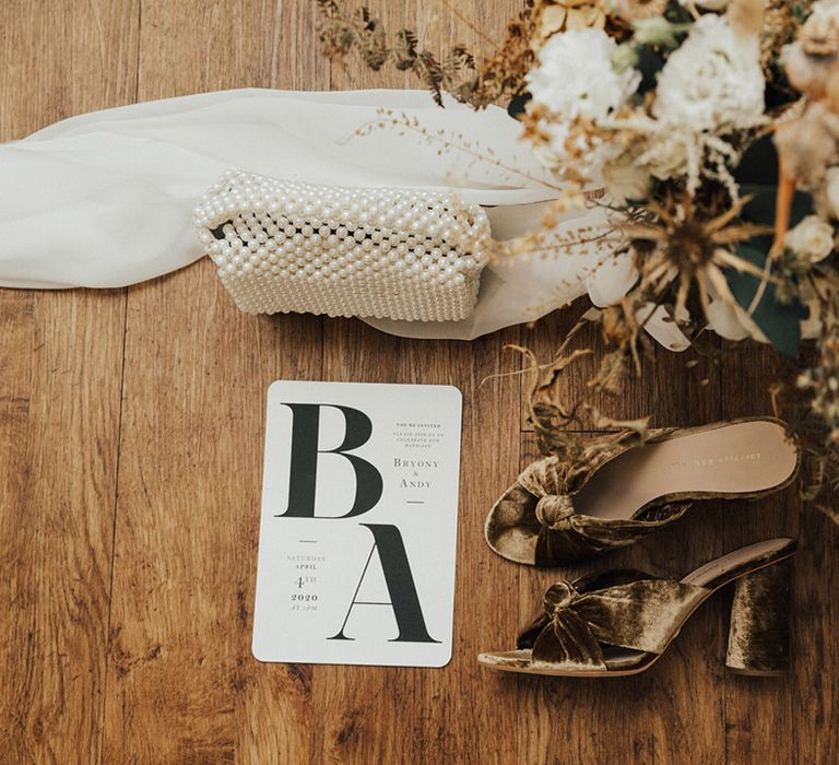 Loeffler Randall wedding shoes beside pearl bag and dried floral bouquet 