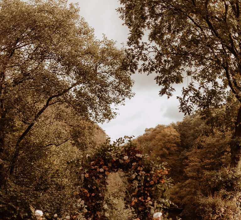 Autumnal wedding flower arch decorating the altar area for the wedding 