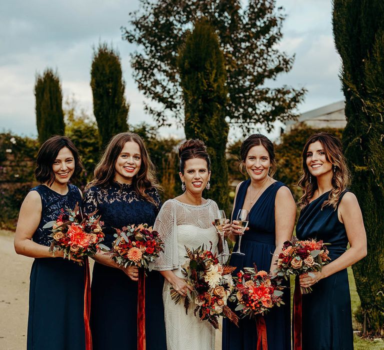 Bridesmaids in navy blue dresses in different styles with the bride for bridal party shots 