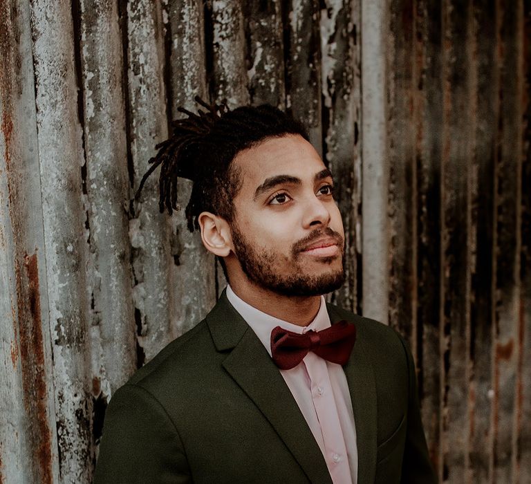 Groom in classic black blazer jacket, white shirt and velvet burgundy bowtie 