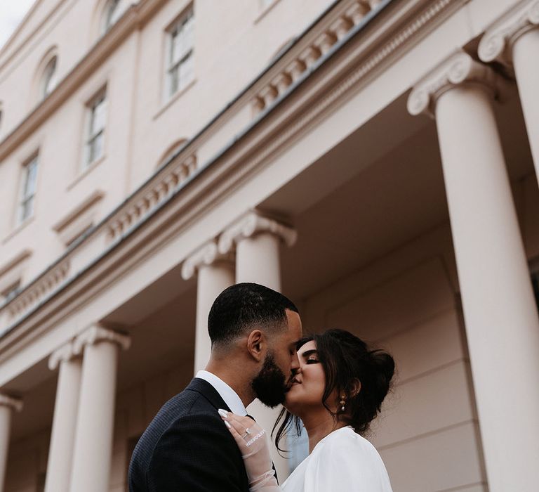 Bride wears personalised sheer gloves whilst kissing her groom