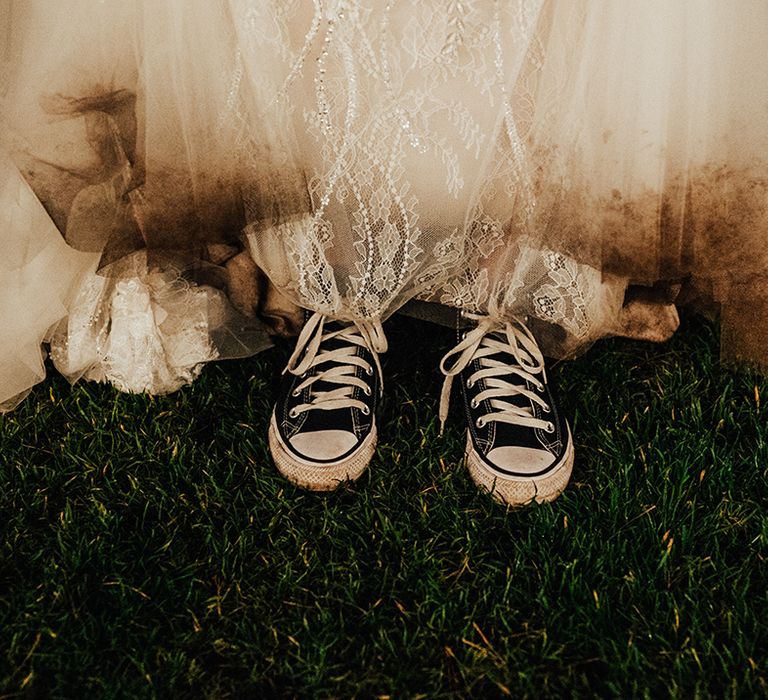 Bride in black Converses for the wedding day with her dress muddy from being outside 