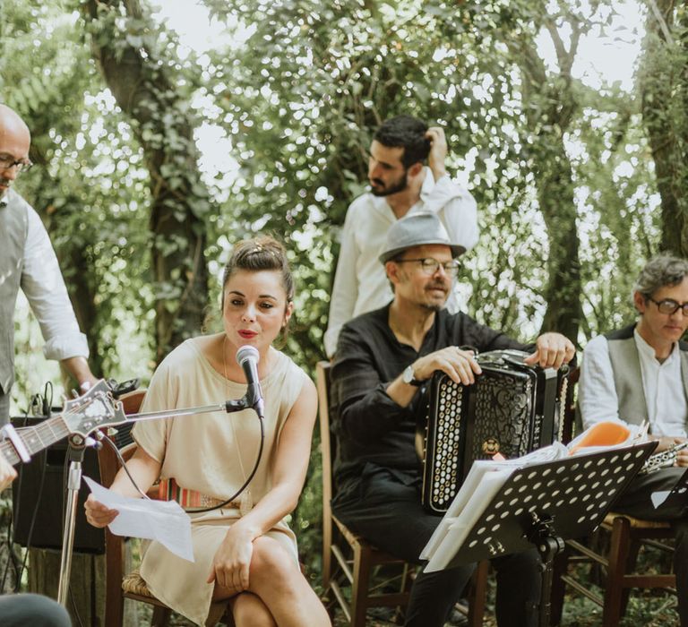 Wedding band performing during woodland wedding ceremony at destination wedding