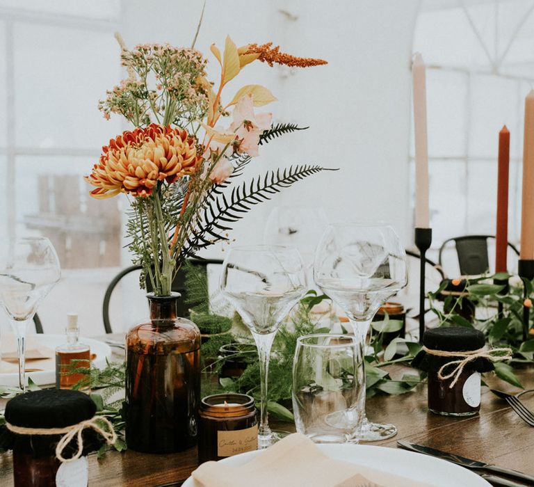 boho wedding place setting with wildflowers in bottles