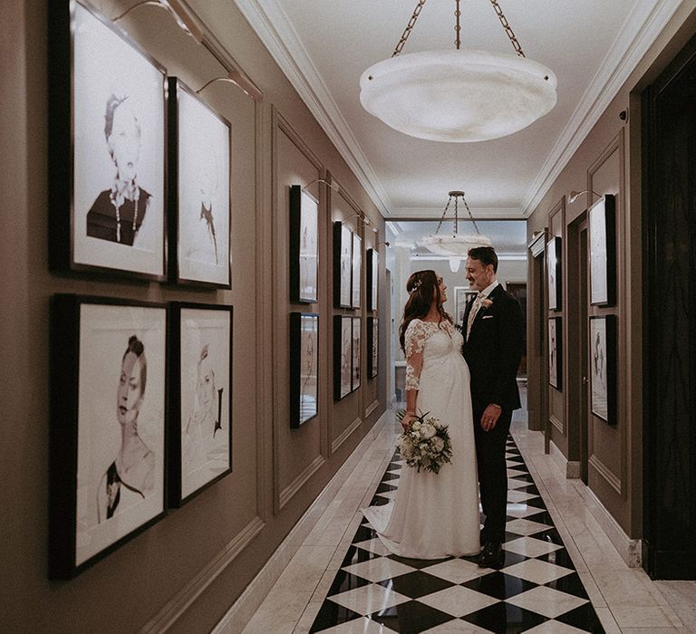 Claridge's wedding venue in London city with the bride in a lace wedding dress with baby bump and groom in navy suit with floral tie