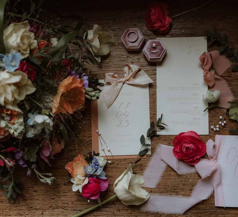 Colourful spring wedding stationery in pastel colours with dusky pink velvet ring box and white closed toe wedding heels 