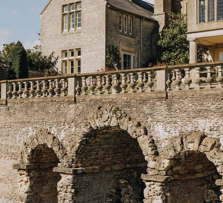 Exterior of Euridge Manor wedding venue with large lake under stone archway 