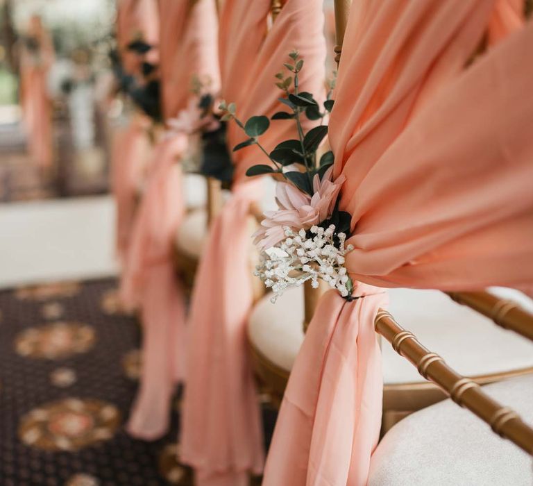 Baby pink chair back decor with white flowers and foliage for Burmese wedding at Bron Eifion wedding venue