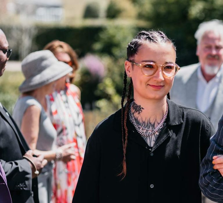 Bride in silver chains, glasses, black shirt and black trousers at Viking themed wedding