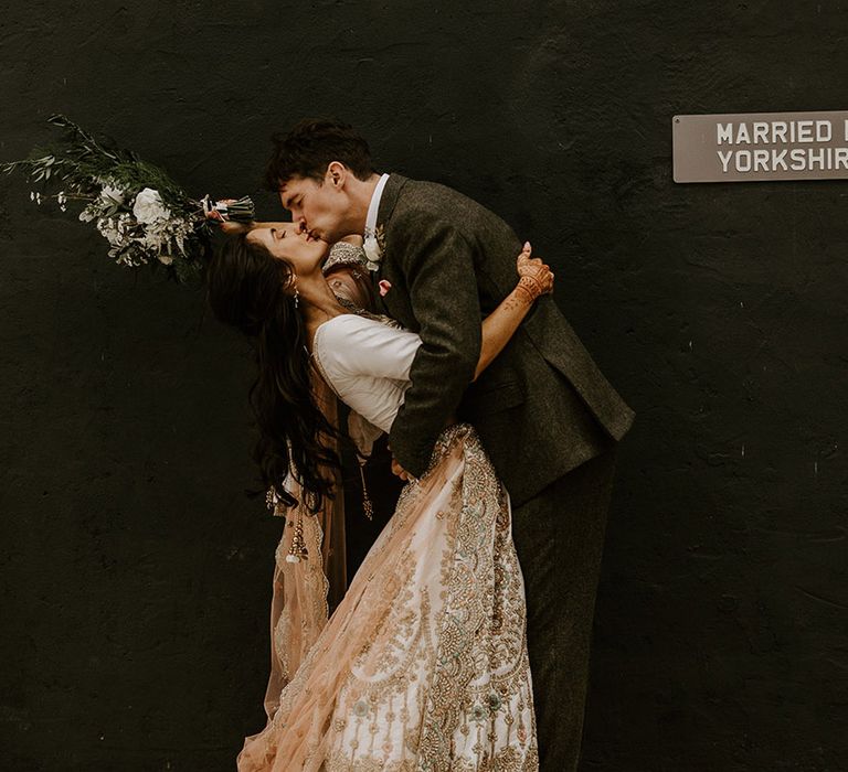 The groom kisses the bride in sweeping kiss on their wedding day 