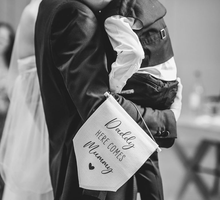 Page boy holding daddy here comes mummy wedding sign 