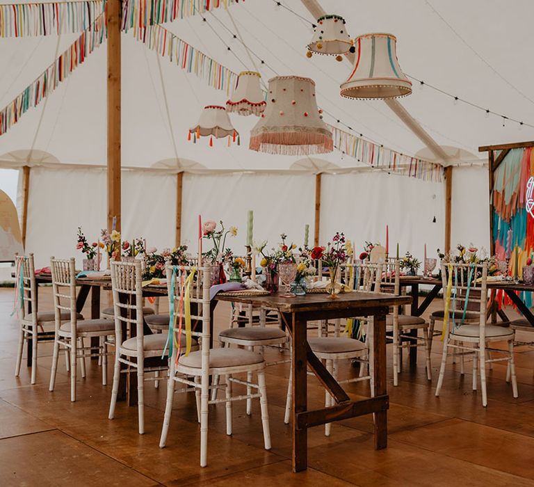 Festival wedding decor is put up around the marquee with rainbow streamers, neon signs, funky lampshades and more 